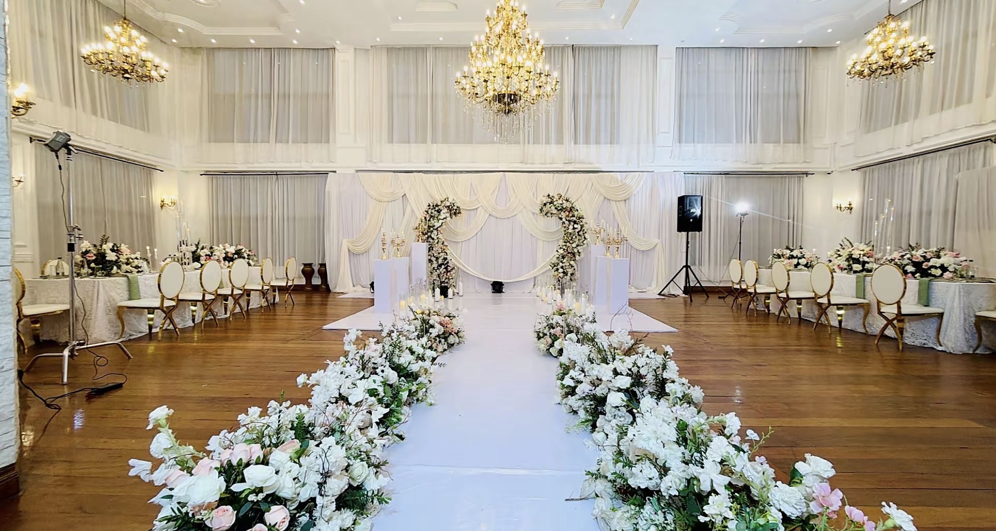 Aisle lined with white florals and gold accents